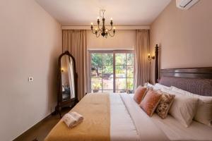 a bedroom with a large bed with a large window at SaffronStays Forest Edge in Siolim