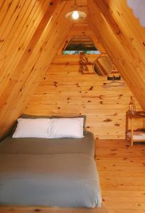 a bedroom with a bed in a wooden cabin at À La Main Farmhouse in Ấp Trường Sơn +7 photos
