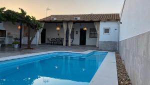 a blue swimming pool in front of a house at Casa Mara in La Herrería