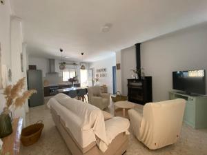 a living room with white furniture and a kitchen at Casa Mara in La Herrería