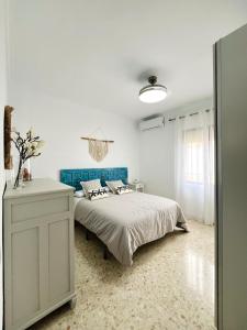 a white bedroom with a bed and a blue headboard at Casa Mara in La Herrería +18 photos