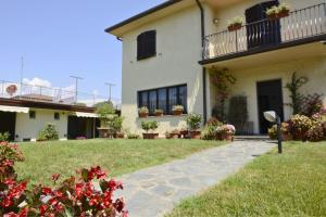 a house with a walkway in front of a yard at Pian di luna in Sarzana