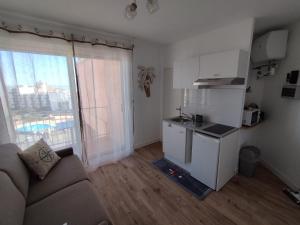 a living room with a couch and a kitchen at Studio vue mer & accès direct à la plage in Le Barcarès