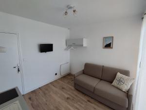a living room with a couch and a tv at Studio vue mer & accès direct à la plage in Le Barcarès
