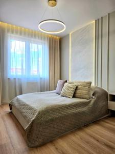 a bedroom with a large bed with a large window at Apartament Ostródzka in Iława