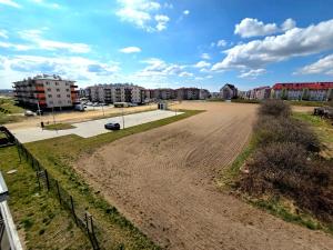 an empty dirt field with buildings in the background at Apartament Ostródzka in Iława
