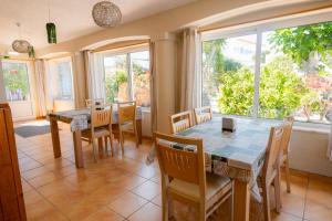 a dining room with a table and chairs and windows at Centre Algarve in Moncarapacho