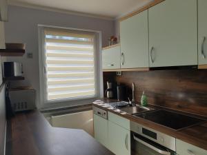 a kitchen with white cabinets and a sink and a window at Euer Ferienheim in Senftenberg +12 photos