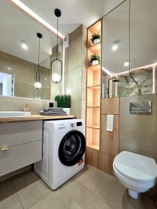 a bathroom with a washing machine and a toilet at Apartament Ostródzka in Iława +26 photos