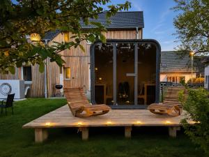 two chairs sitting on a wooden deck in a yard at Urlaub auf dem Land in Triepkendorf +14 photos