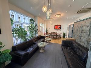 a living room with a leather couch and a table at Elysee Hyde Park in London