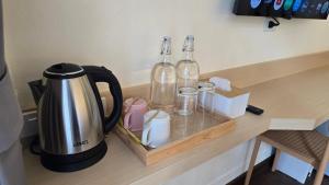 a counter with a coffee maker and two glass bottles at Norns Silom Cafe & Stay in Bangkok