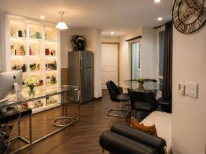 a dining room with a glass table and a refrigerator at The Greenway Sukhumvit 50 in Phra Khanong
