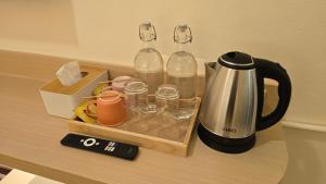 a counter with a coffee maker and two bottles and glasses at Norns Silom Cafe & Stay in Bangkok