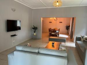 a living room with a couch and a table at Hungwe House in Victoria Falls