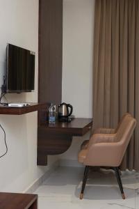 a desk with a chair and a television in a room at The Aero Lounge Hotel 2kms From Airport in Amritsar