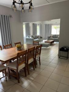 a dining room with a wooden table and chairs at Hungwe House in Victoria Falls