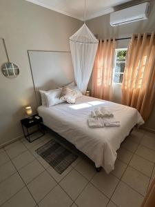a bedroom with a bed with two towels on it at Hungwe House in Victoria Falls +27 photos