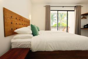 a bedroom with a large white bed and a window at Azul Retreat in Dhigurah