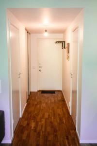 a hallway with a white door and a wooden floor at Green Balcony Studio near Metro in Norsborg