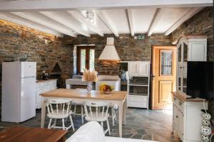 a kitchen with a wooden table and white appliances at Liostasi Tinos in Agios Fokas