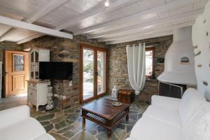 a living room with a stone wall at Liostasi Tinos in Agios Fokas
