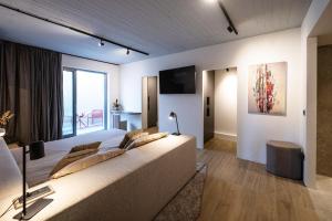 a living room with a large couch and a large window at Nerea Residences in Schinias