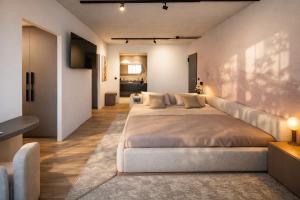 a large bedroom with two beds and a television at Nerea Residences in Schinias