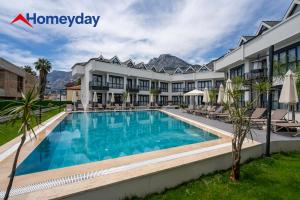 a hotel with a swimming pool in front of a building at Whitestone Homes in Antalya