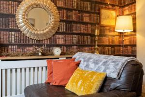 a living room with a leather couch and a mirror at Vintage 2-bed flat with free parking in Measham in Measham