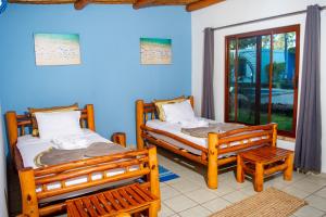 two beds in a room with blue walls at Telvina Beach Lodge in Vilanculos
