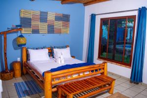 a bedroom with a wooden bed and a window at Telvina Beach Lodge in Vilanculos