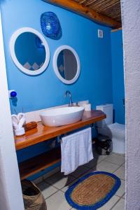 a bathroom with a sink and two mirrors on the wall at Telvina Beach Lodge in Vilanculos +116 photos
