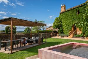 an outdoor patio with a table and chairs and a pool at Apartamentos en la Rectoria de Regencós in Regencós