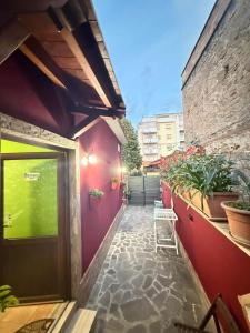 a walkway leading to a building with a door and plants at B&B JOY in Nettuno