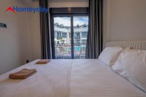 a bedroom with a large bed with two towels on it at Whitestone Homes in Antalya +41 photos