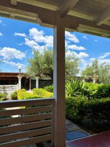a porch with a fence and bushes at Demetra Apartment Sperlonga in Sperlonga