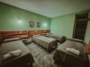 a room with three beds in a room at Piedra Alta Hotel & Restaurante in Itá Ibaté