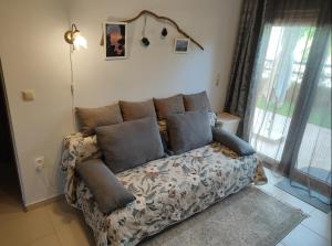 a couch with pillows in a living room at SiviriLovelyApartment in Siviri