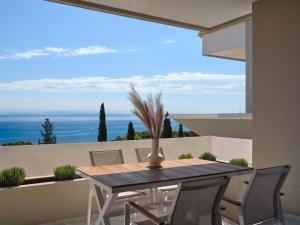 Ein Tisch und Stühle auf einem Balkon mit Blick auf das Meer in der Unterkunft The Sall Complex B - Sea View Suites, by ZanteWize in Agios Nikolaos