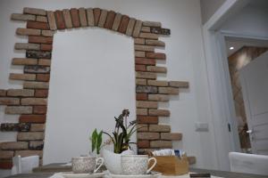 a dining room with a brick wall and mugs on a table at Sabbia e Coralli in Muravera