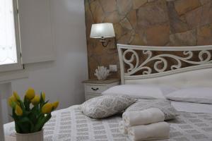 a bedroom with a bed with towels on it at Sabbia e Coralli in Muravera +14 photos
