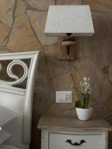 a white table with a light on a stone wall at Sabbia e Coralli in Muravera