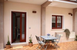 a patio with a table and chairs in front of a house at Sabbia e Coralli in Muravera