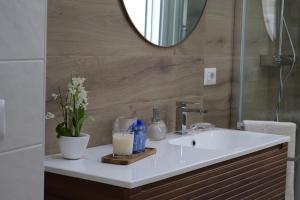 a bathroom sink with a mirror and flowers on it at Sabbia e Coralli in Muravera