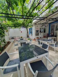 an outdoor patio with tables and chairs and trees at Nese Otel in Çeşme