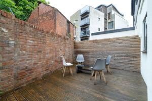 two chairs and a bench on a brick wall at Cozy Urban 2BR with courtyard in Gloucestershire