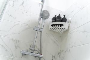 a shower with a toothbrush holder in a bathroom at Cozy Urban 2BR with courtyard in Gloucestershire +14 photos