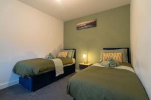 a bedroom with two beds and a lamp in it at Cozy Urban 2BR with courtyard in Gloucestershire