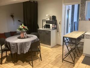 a living room with a table and a kitchen at Un petit truc en plus in Brienne-le-Château